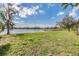 Expansive backyard featuring a scenic waterfront view with a private dock and lush green lawn at 2050 W Bearss Ave, Tampa, FL 33618