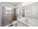 Bathroom featuring white vanity and tiled shower with glass door at 2050 W Bearss Ave, Tampa, FL 33618