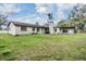 Exterior view of a charming single-story home featuring a carport, chimney, and lush green lawn at 2050 W Bearss Ave, Tampa, FL 33618