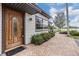 Inviting front entrance with a decorative wood door, brick pathway, and manicured landscaping at 2050 W Bearss Ave, Tampa, FL 33618