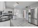 Well-lit kitchen with stainless steel appliances, tile flooring, and white cabinets at 2050 W Bearss Ave, Tampa, FL 33618