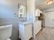 Bathroom with a white vanity, tiled walls, and a view into the kitchen at 2111 26Th S St, St Petersburg, FL 33712