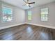 Bedroom featuring new dark wood floors, a ceiling fan, and bright windows at 2111 26Th S St, St Petersburg, FL 33712