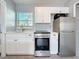 Modern kitchen with white cabinets, stainless steel appliances, and a bright window at 2111 26Th S St, St Petersburg, FL 33712