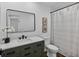 Well-lit bathroom with white walls, vanity with storage, black hardware, and decorative prints on the wall at 227 84Th Ne Ave, St Petersburg, FL 33702