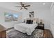 Cozy bedroom with neutral walls, wood floors, a ceiling fan, and a large window that offers nice sunlight at 227 84Th Ne Ave, St Petersburg, FL 33702