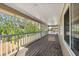 Long screened-in porch with wood flooring, white railings, and a light-colored ceiling for outdoor relaxation at 227 84Th Ne Ave, St Petersburg, FL 33702