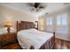 A bedroom features hardwood floors, plantation shutters, a ceiling fan, and a wooden carved-style bed frame at 2717 Via Cipriani # 614B, Clearwater, FL 33764