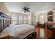 Spacious bedroom with hardwood floors, plantation shutters, a ceiling fan, and a cozy fireplace at 2717 Via Cipriani # 614B, Clearwater, FL 33764