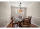 Cozy dining area with hardwood floors, elegant lighting, and a window with plantation shutters at 2717 Via Cipriani # 614B, Clearwater, FL 33764