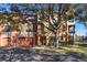 Charming exterior view with a large tree, garage, and lush greenery surrounding the property at 2717 Via Cipriani # 614B, Clearwater, FL 33764