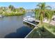 Aerial view of the waterfront canal with a boat docked, lush backyard with palm trees and neighborhood homes at 320 Georgia Ave, Crystal Beach, FL 34681