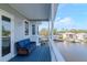 Relaxing covered balcony with blue wooden deck, white railing, and comfortable blue wicker furniture at 320 Georgia Ave, Crystal Beach, FL 34681