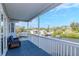 Relaxing covered balcony with blue wooden deck, white railing, and comfortable blue wicker furniture at 320 Georgia Ave, Crystal Beach, FL 34681