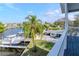 Scenic balcony view of a waterfront canal with boats docked, lush yard with palm trees and neighborhood homes at 320 Georgia Ave, Crystal Beach, FL 34681