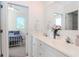 Well-lit bathroom with double sinks, white cabinets, and an open view into an adjacent bedroom at 320 Georgia Ave, Crystal Beach, FL 34681