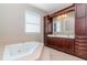 Spacious bathroom featuring a large soaking tub, dual sinks with wooden cabinets and tile floors at 320 Georgia Ave, Crystal Beach, FL 34681