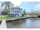 Spacious two-story waterfront home with multiple balconies, lush lawn, and private dock at 320 Georgia Ave, Crystal Beach, FL 34681