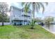 Spacious two-story waterfront home with multiple balconies, lush lawn, and private dock at 320 Georgia Ave, Crystal Beach, FL 34681