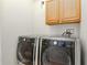 Well-equipped laundry room with front loading LG washer and dryer set and a wooden cabinet above at 320 Georgia Ave, Crystal Beach, FL 34681