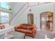 Cozy living room featuring a grand staircase, large windows, and a view of the kitchen at 320 Georgia Ave, Crystal Beach, FL 34681