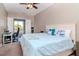 Bright bedroom featuring a private balcony, an office setup, and a large comfortable bed at 320 Georgia Ave, Crystal Beach, FL 34681