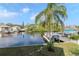 Picturesque water view highlighting the canal, boat dock, and tropical palm trees surrounding the property at 320 Georgia Ave, Crystal Beach, FL 34681