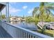 Scenic water view from the porch, showcasing the canal, boat docks, and lush tropical foliage at 320 Georgia Ave, Crystal Beach, FL 34681