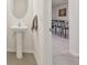 Well-lit half-bath featuring a pedestal sink and an oval mirror, conveniently located near the kitchen at 3313 Pleasant Willow Ct, Brandon, FL 33511