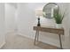 Light-filled hallway featuring a console table adorned with a lamp and decorative greenery at 3313 Pleasant Willow Ct, Brandon, FL 33511