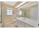 Light-filled bathroom featuring vanity with sink and mirror and shower/tub combo with tile surround at 37157 Foxrun Pl, Zephyrhills, FL 33542