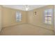 Neutral bedroom showcasing carpet flooring, natural light from shuttered windows and a ceiling fan at 37157 Foxrun Pl, Zephyrhills, FL 33542