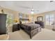 Cozy bedroom with carpet, large windows, plantation shutters, and dark wood furniture at 37157 Foxrun Pl, Zephyrhills, FL 33542