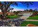 Charming single-story home with lush lawn, mature tree, and two-car garage, bathed in warm light at 37157 Foxrun Pl, Zephyrhills, FL 33542