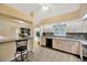 Bright kitchen featuring tile floors, light wood cabinets, and a convenient breakfast bar area at 37157 Foxrun Pl, Zephyrhills, FL 33542