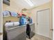 Laundry room featuring washer, dryer, overhead rack and door to storage at 37157 Foxrun Pl, Zephyrhills, FL 33542