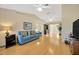 Bright living room with hardwood floors, neutral walls, ceiling fans, and a comfortable blue couch at 37157 Foxrun Pl, Zephyrhills, FL 33542