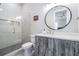 Contemporary bathroom with a glass-enclosed shower, round mirror, and sleek vanity at 619 Danube Ave, Tampa, FL 33606