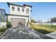 A gray brick driveway leads up to the two-car garage of this bright two story home at 619 Danube Ave, Tampa, FL 33606