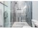 Close up of walk-in shower featuring vertical tiles, a shower head, and a built-in soap niche at 619 Danube Ave, Tampa, FL 33606