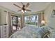 Bedroom featuring a ceiling fan, beach view window, and sliding glass door to the porch at 6365 Bahia Del Mar Blvd # 112, St Petersburg, FL 33715