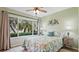 Relaxing bedroom with tropical views from the large window, featuring a ceiling fan and light colored walls at 6365 Bahia Del Mar Blvd # 112, St Petersburg, FL 33715