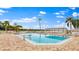 Large outdoor pool surrounded by lounge chairs with palm trees and a view of the water at 6365 Bahia Del Mar Blvd # 112, St Petersburg, FL 33715