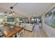 Open concept dining area with wood table, white chairs, and decorative lighting overlooking the living room at 6365 Bahia Del Mar Blvd # 112, St Petersburg, FL 33715