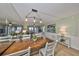 Open concept dining area with wood table, white chairs, and modern lighting adjacent to the living room at 6365 Bahia Del Mar Blvd # 112, St Petersburg, FL 33715