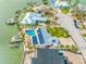 Aerial view of property with solar panels, pool, and boat dock on the canal at 7984 1St S Ave, St Petersburg, FL 33707