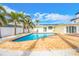 Backyard pool with a brick patio, palm trees, and a seamless transition to indoor-outdoor living at 7984 1St S Ave, St Petersburg, FL 33707