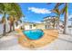 Backyard pool featuring a brick patio, adjacent to a home with solar panels and surrounded by palm trees at 7984 1St S Ave, St Petersburg, FL 33707