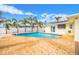 Inviting pool area with brick patio, white fence, palm trees, and easy access to the house at 7984 1St S Ave, St Petersburg, FL 33707