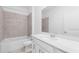 Bathroom featuring a shower-tub combo, neutral tile, and a vanity with bright lighting at 8069 Shore Lake Dr, Englewood, FL 34224